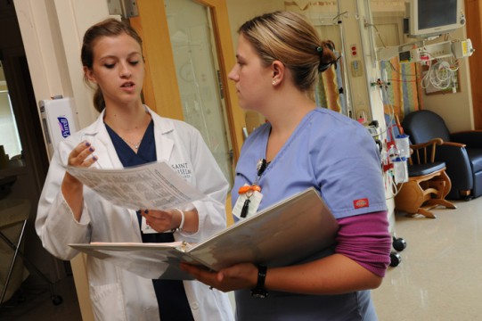 Saint Anselm 2013 ISURF Nursing student Caleigh MacDonald (left) reviews a protocol with a staff nurse in the DHMC Pediatric Care Unit. (photo by John Gilbert Fox)