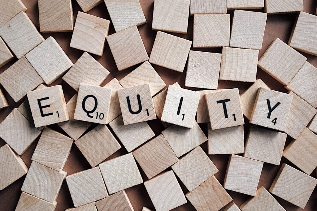 Equity spelled out with Scrabble tiels