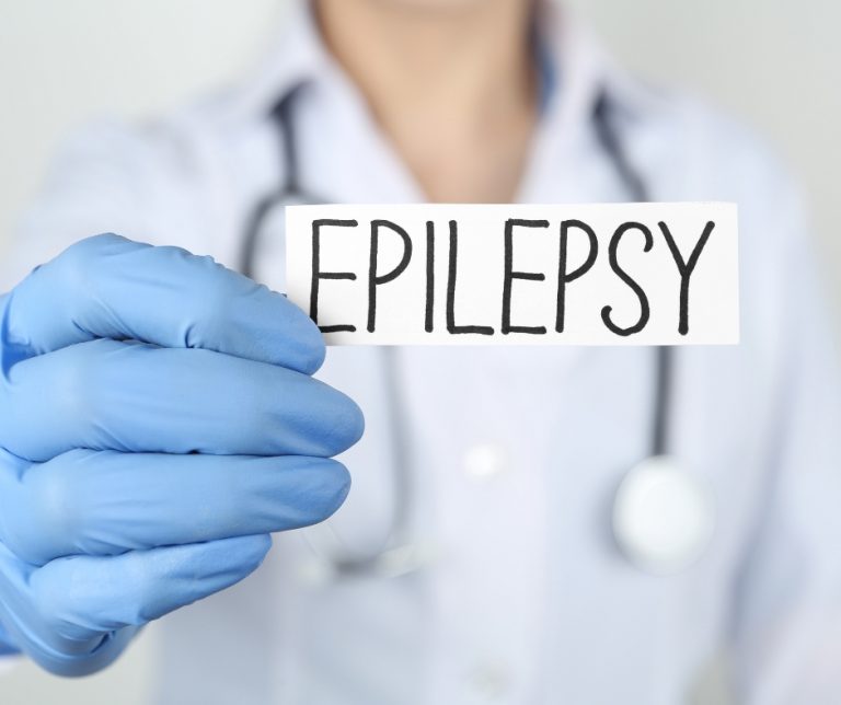 Clinician holding up a sign with the word "Epilepsy".