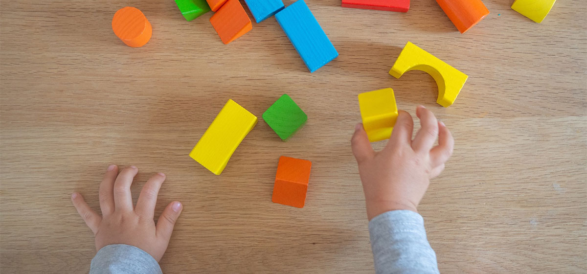 Infant hands playing with blocks